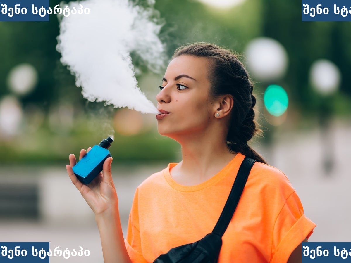 ქალი ვაპინგით დაკავებულია პარკში, საქართველო