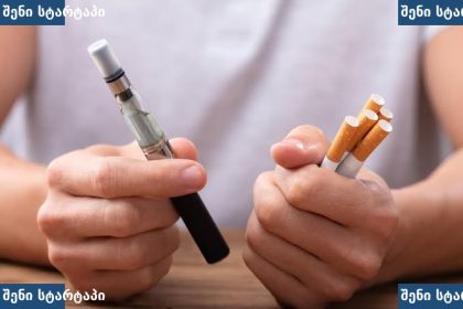 კაცი ხელში უჭირავს ვაპორიზატორი და სიგარეტები, საქართველო