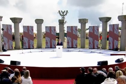 პრეზენტაცია სცენაზე, ფონზე ქართული დროშები, საქართველო