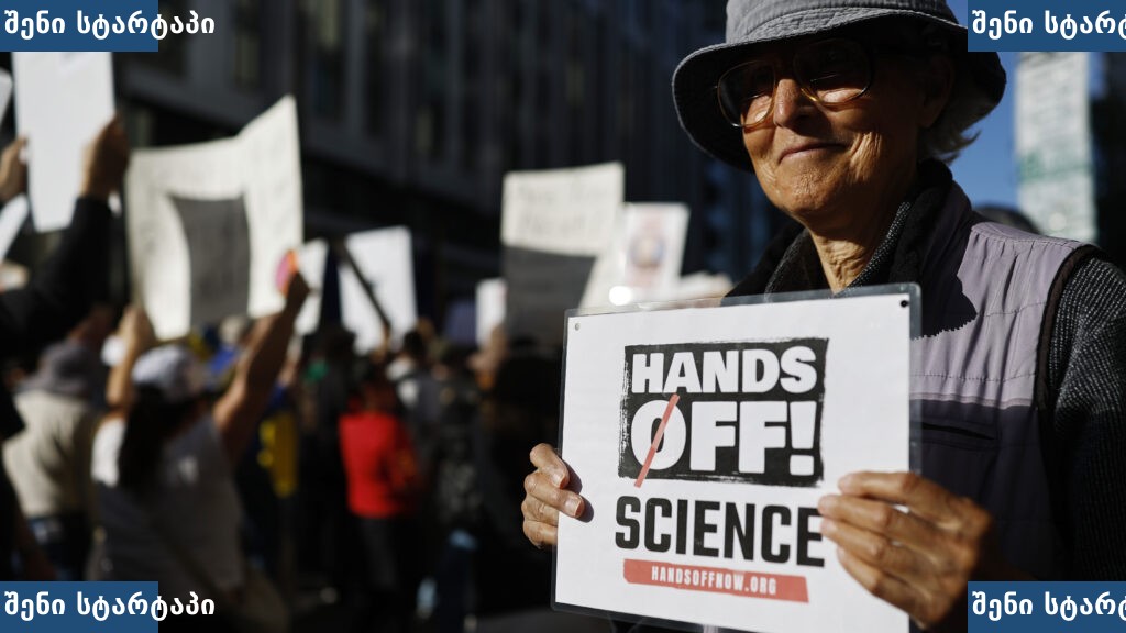 მიტინგზე ქალი პლაკატით - 'Hands Off Science!' — საქართველო