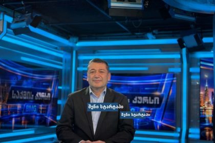 მამაკაცი მედია სტუდიაში, ფონზე ეკრანები — საქართველო