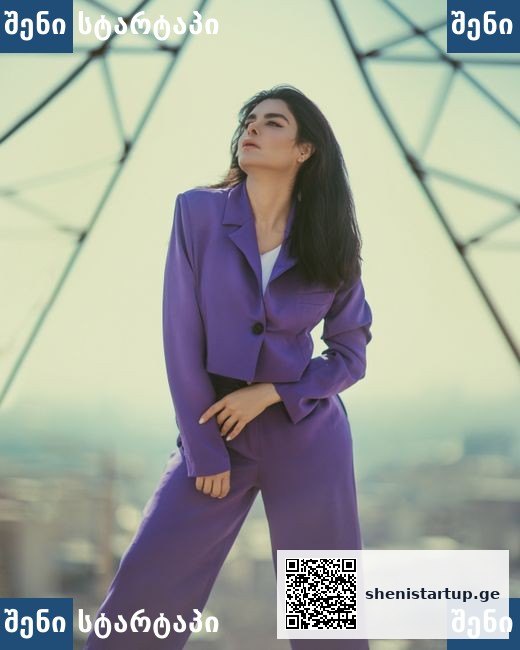 მოდელი ვიოლეტურ კოსტიუმში, ფონზე ელექტრო სვეტები — საქართველო