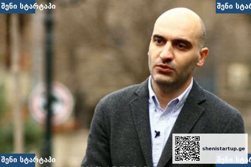 მამაკაცი ინტერვიუს დროს, ფონზე ქალაქის ხედები — საქართველო