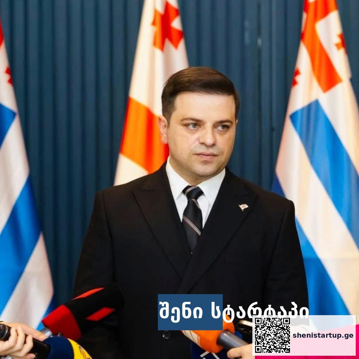 პოლიტიკოსი პრესკონფერენციაზე, საქართველოს დროშები ფონზე