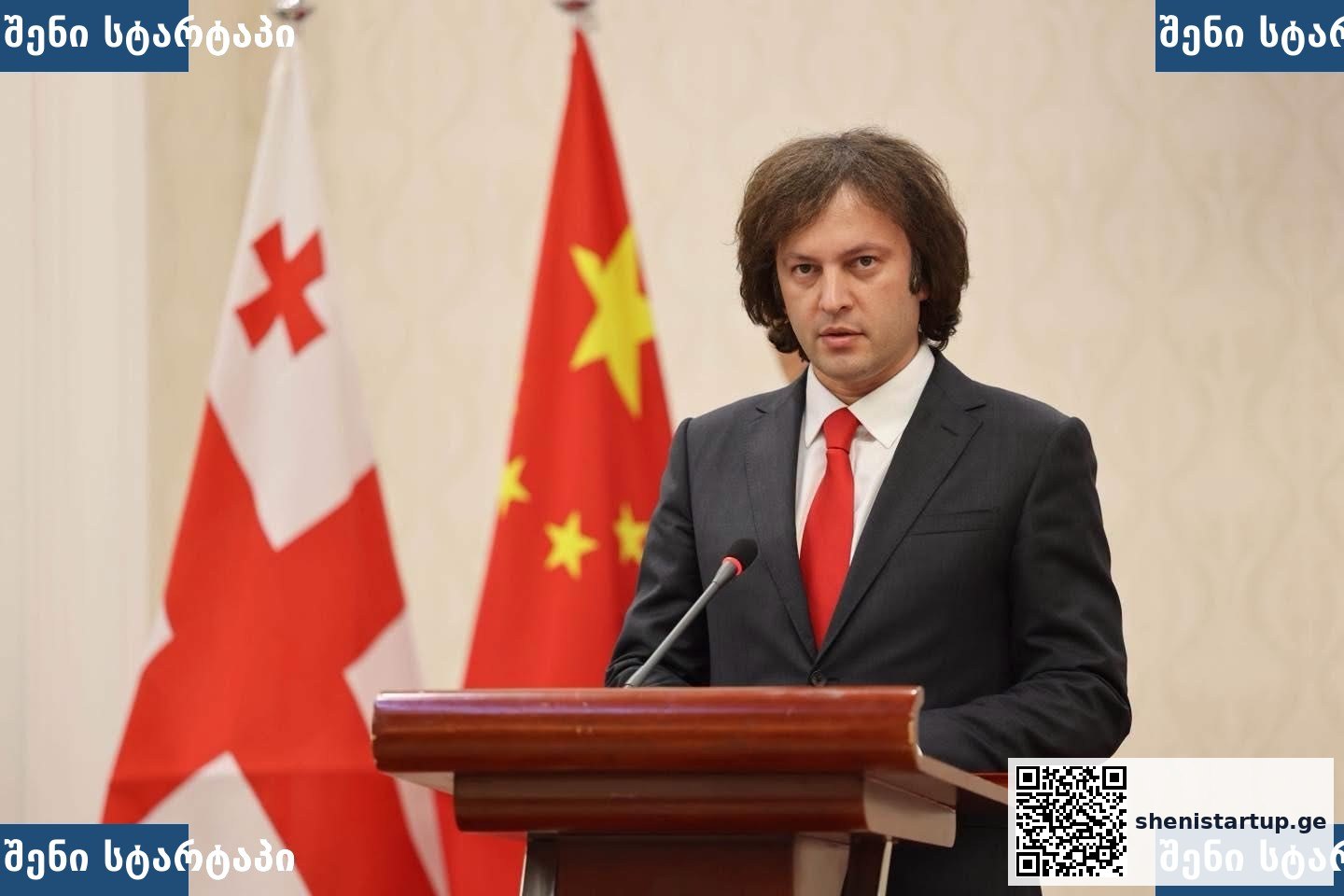 პოლიტიკოსი სიტყვით გამოდის, ფონზე საქართველოს და ჩინეთის დროშები — საქართველო